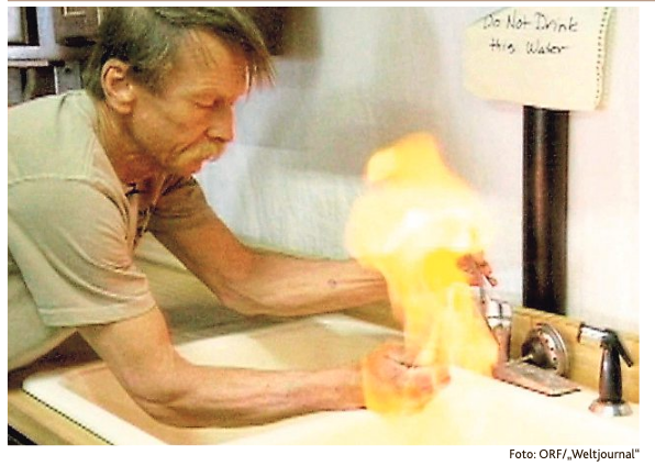 Screenshot aus der Dokumentation „Gasland“: Ein Mann mit Schnauzbart entzündet sein Leitungswasser. Die Stichflamme ist deutlich zu erkennen. Über dem Wasserhahn hängt ein Zettel, auf dem handgeschrieben steht: Do Not Drink This Water.